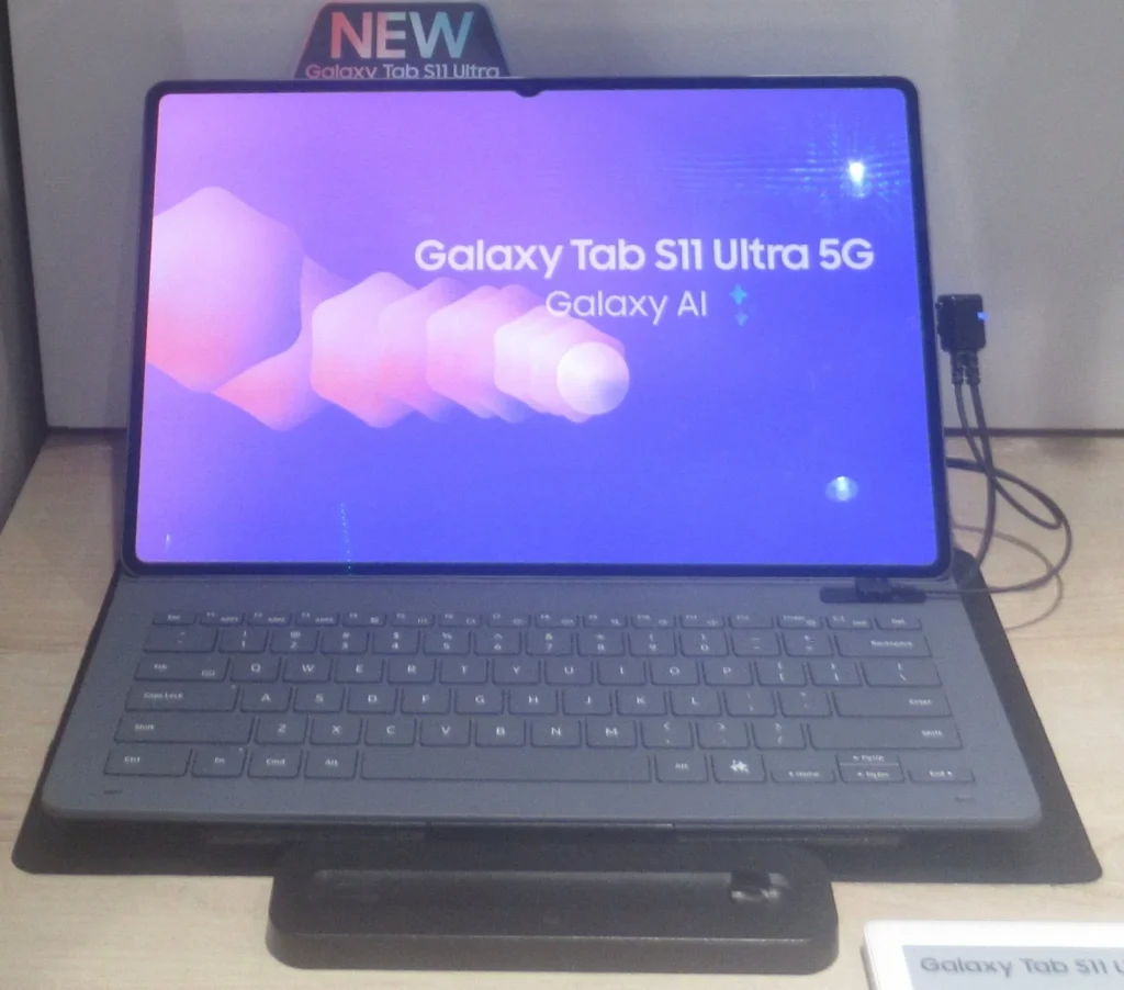Galaxy Tab S11 Ultra gắn bao bàn phím, màn hình bật, đặt trên kệ trưng bày cửa hàng