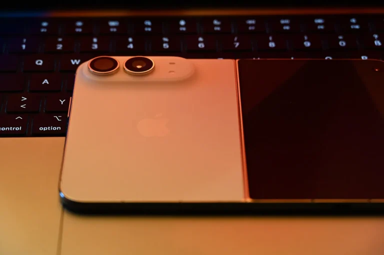 iPhone Duo gập lại, nằm ngang trên bàn phím laptop, thấy mặt lưng và cụm camera