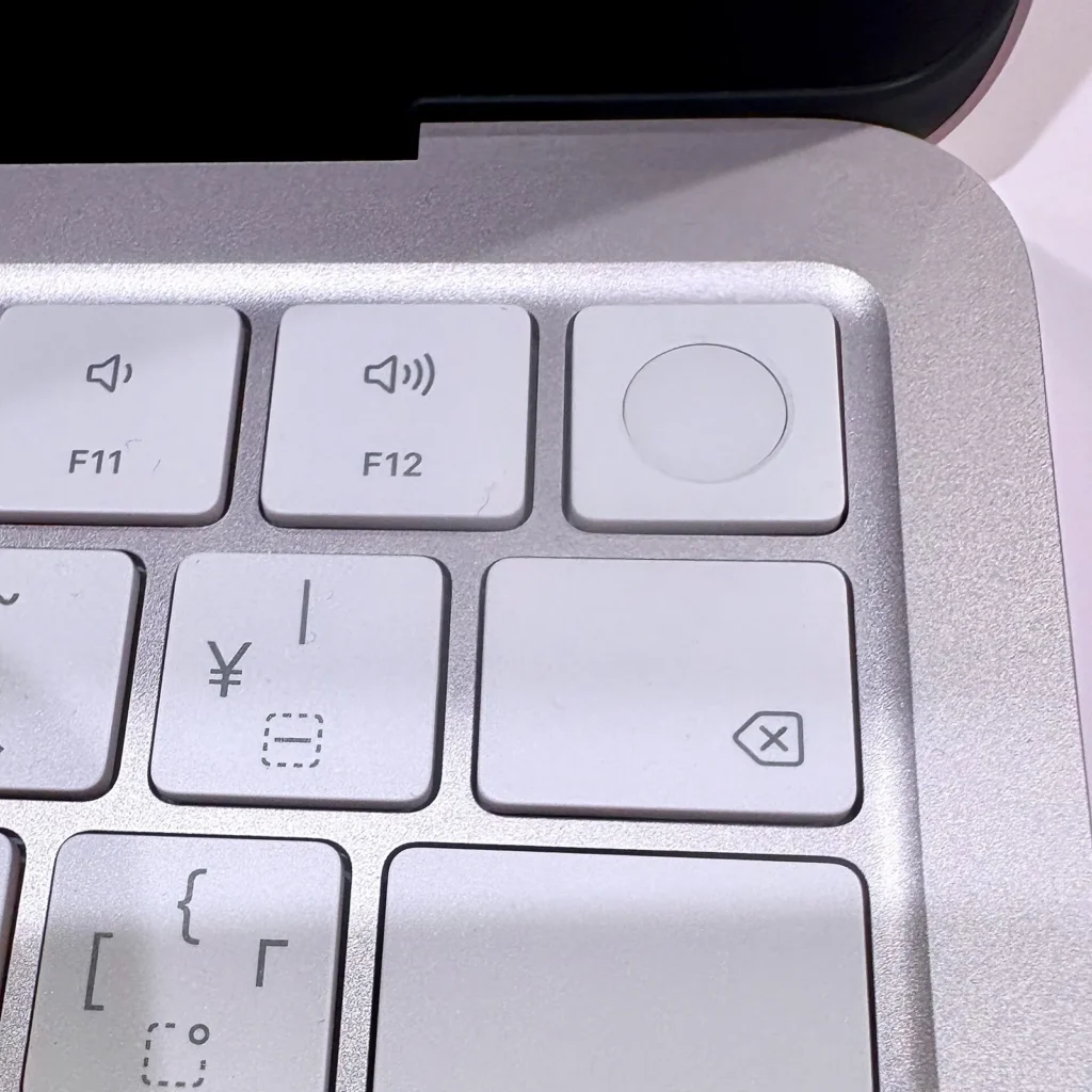 Cận cảnh góc phải bàn phím MacBook Neo bản Touch ID: phím F11, F12, nút Touch ID và phím ¥ của bố cục JIS
